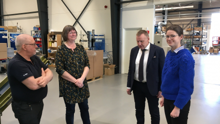 Fire personer på rundvinsning i industrihal