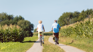 To ældre mennesker på hver sin cykel