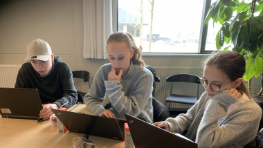 Tre skoleelever arbejder ved deres computere