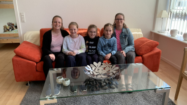 Familiemedlemmer samlet i en sofa