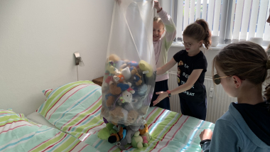 Børn tømmer en pose med bamser.