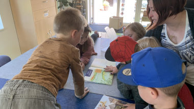 Børn læser bøger sammen i en daginstitution.
