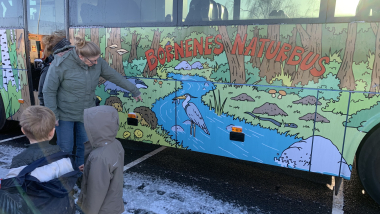 Børnene snakker om de tegnede figurer på naturbussen.