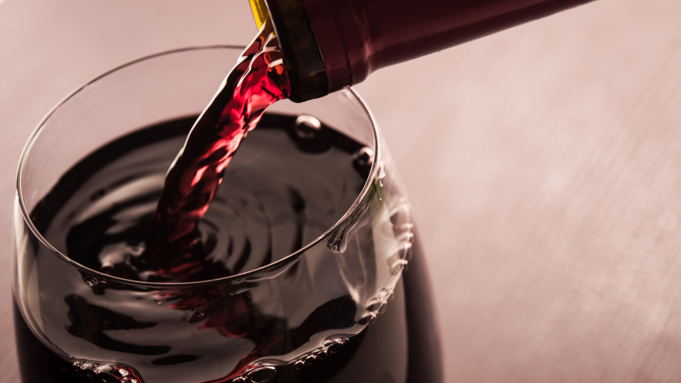 rødvin hældes i glas