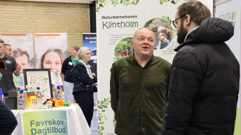to personer i samtale foran messestand