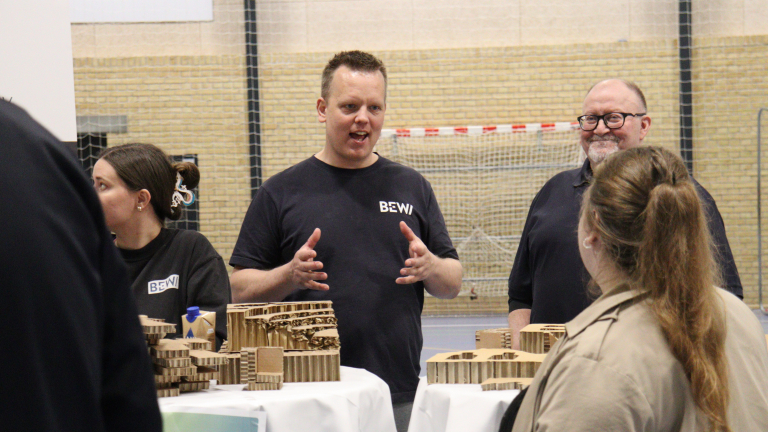 personer i samtale ved messestand