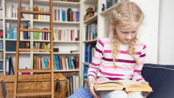 Lille pige læser i en bog