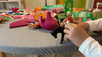 Daginstitutionsbarn leger med lego ved et bord