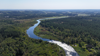 dronefoto af stor å i grønt landskab