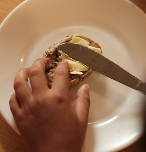 Barnehånd smører brød